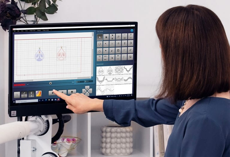 Woman touching a computer with BERNINA Qmatic software shown